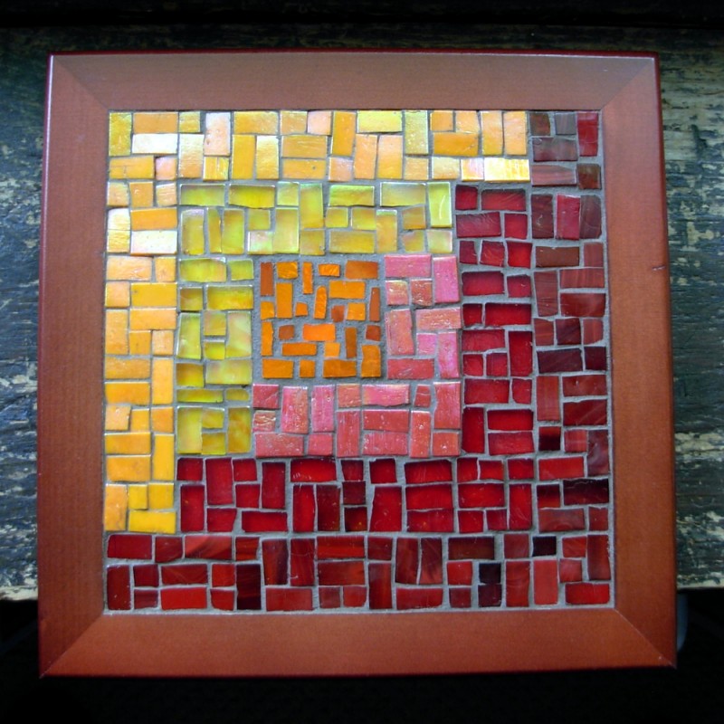 Asymmetric Log Cabin Trivet in Orange and Red by Margaret Almon. Glass on wood, 8 inches.