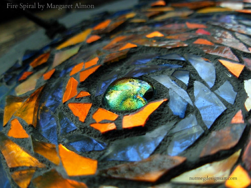 Fire Spiral Mandala by Margaret Almon. Glass, gold smalti, dichroic on slate, 7 inches.